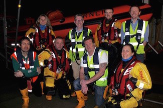 Showing their own respect for the sea are Cowes RNLI lifeboat crew and shore team wearing lifejackets