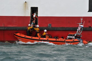 Cowes RNLI lifeboat alongside Red Funnel car ferry during casualty transfer exercise
