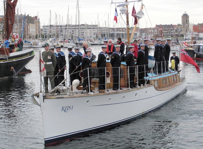 Royal Navy Sailors on the deck of Riis I, which was built in 1920 on the Clyde, salute upon leaving Dunkerque