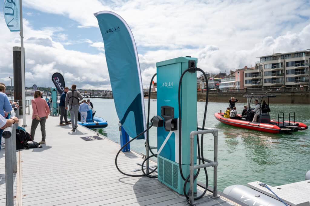 Aqua superPower 75kW Fast Charger installed on a pontoon. Pictured with an electric RiB in the background demonstrating the technology.