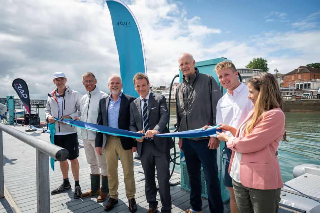 The official ribbon cutting, opening the 75 Kw Fast Charging stations. MP Bob Seely holds the gold coloured scissors and is joined by representatives from the marine industry