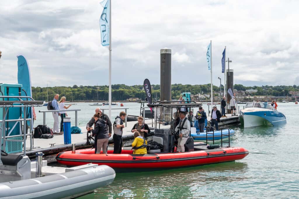 Guests board a red electric RiB to head out from the pontoon and experience the benefits of electric boat technology.